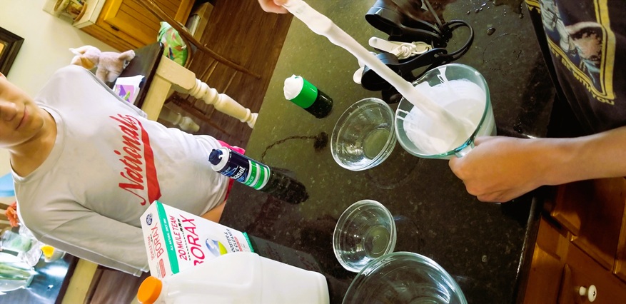 Homeschool science experiment making borax and shaving cream slime.